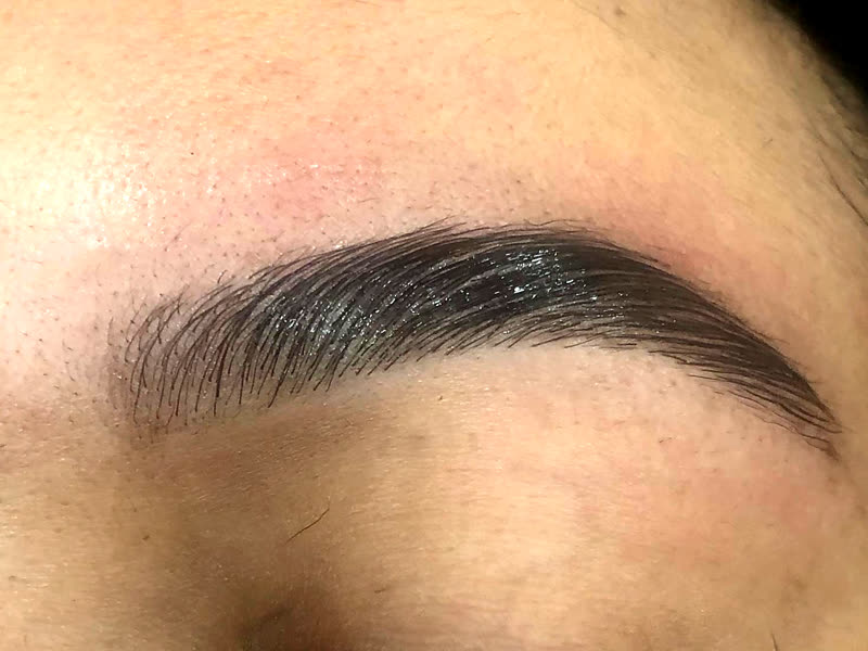 Macro de una ceja laminada con el pelo peinado hacia arriba